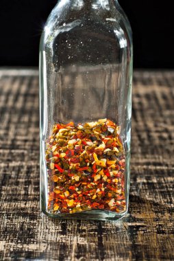 Cam kavanozdaki çeşitli baharatların karışımı. Siyah, eski püskü bir tahtada baharatlar ve baharatlar. Baharat yakınındaki metin için boş alan ve kopyalama alanı.