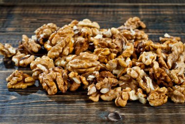 Ceviz dokusunu kapat. Eski ahşap bir tahtanın üzerinde soyulmuş fındık parçaları. Sefil kahverengi tahtada yemek..