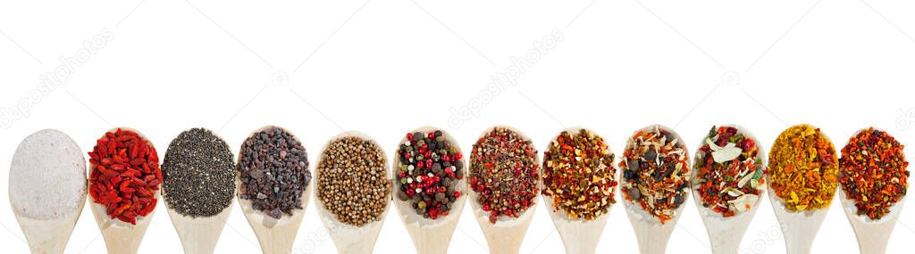 A mixture of different spices in a wooden spoon. Spices and seasonings isolated on a white background. Mix in a heap close up.