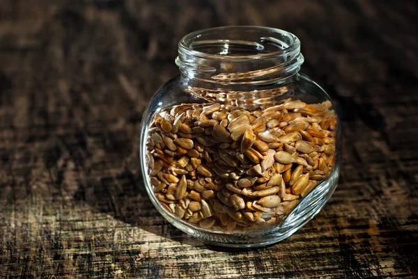 Solrosfrön Genomskinlig Glasburk Nötter Gammal Sjabbig Bräda Burk Ett Brunt — Stockfoto