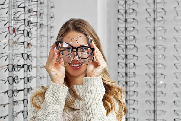 Una Donna Sceglie Gli Occhiali Nel Negozio Bionda Maglione Beige — Foto Stock