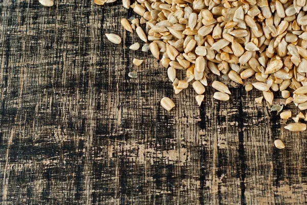 Geschälte Sonnenblumenkerne Auf Einem Braunen Zerkratzten Brett Textur Von Nüssen — Stockfoto