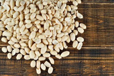 Kahverengi bir tahtada soyulmuş fıstık. Ahşap bir masada fındık dokusu. Bir yığın fındık..