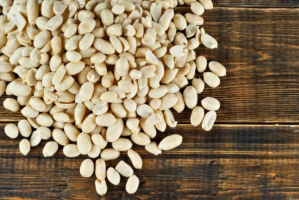 Kahverengi bir tahtada soyulmuş fıstık. Ahşap bir masada fındık dokusu. Bir yığın fındık..