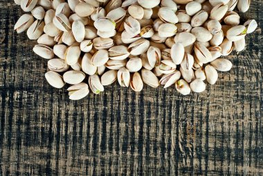 Pistachio dokusunu yakından çek. Siyah tahta üzerinde fındıklar. Fındık yakınındaki metin için boşluk ve boş alanı kopyala.