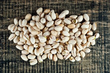Pistachio dokusunu yakından çek. Siyah tahta üzerinde fındıklar.