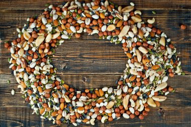 Pek çok çatlak türü kapanır. Tahtadaki farklı fındıkların dokusu. Fındıklar kahverengi bir masanın üzerine yığılır. Ürün veya metin için boşluk ve boş alanı kopyala.