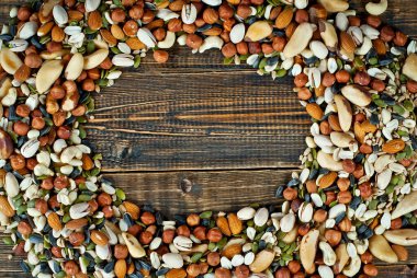 Pek çok çatlak türü kapanır. Tahtadaki farklı fındıkların dokusu. Fındıklar kahverengi bir masanın üzerine yığılır. Ürün veya metin için boşluk ve boş alanı kopyala.