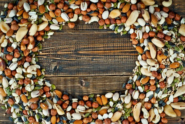 Pek çok çatlak türü kapanır. Tahtadaki farklı fındıkların dokusu. Fındıklar kahverengi bir masanın üzerine yığılır. Ürün veya metin için boşluk ve boş alanı kopyala.