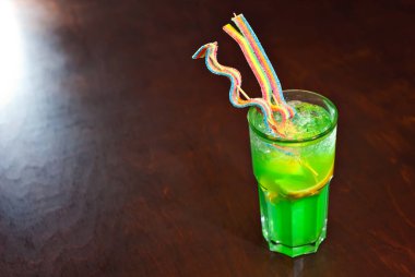 Ahşap bir masada yeşil kokteyl. Limonlu meyve kokteylinde keskinlik. Alkolik içki, yakından..