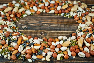 Pek çok çatlak türü kapanır. Tahtadaki farklı fındıkların dokusu. Fındıklar kahverengi bir masanın üzerine yığılır. Ürün veya metin için boşluk ve boş alanı kopyala.