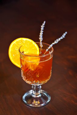 Ahşap bir masada portakal kokteyli. Portakal ve lavanta karışımında keskinlik. Alkolik içki yakın çekim. Şarap ve beyaz şarap..