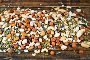 Pek çok çatlak türü kapanır. Tahtadaki farklı fındıkların dokusu. Kahverengi bir masada fındıklar yığılır..