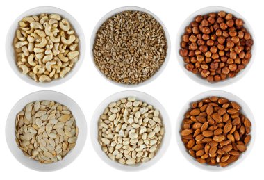 Ceviz, fıstık, fındık, badem, ayçekirdeği, kabak çekirdeği. Beyaz arka planda izole edilmiş beyaz bir kasede fındıklar.