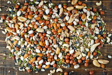 Pek çok çatlak türü kapanır. Tahtadaki farklı fındıkların dokusu. Kahverengi bir masada fındıklar yığılır..