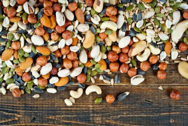 Pek çok çatlak türü kapanır. Tahtadaki farklı fındıkların dokusu. Kahverengi bir masada fındıklar yığılır..