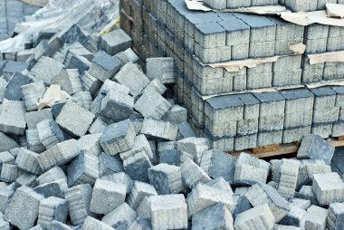 Yığının üzerinde yepyeni kaldırım taşları var. Mavi granit kaldırım taşları yaklaşıyor. Kaldırımlar için taş küpler. Kaldırımların tamiri.