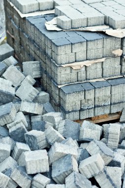 Yığının üzerinde yepyeni kaldırım taşları var. Mavi granit kaldırım taşları yaklaşıyor. Kaldırımlar için taş küpler. Kaldırımların tamiri.