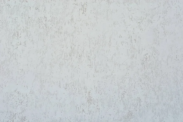 White concrete wall with cracks and scratches. Texture of scratched, old and worn wall close up.