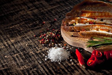 Siyah arka planda tahta bir tahtada dilimlenmiş biftek. Eski püskü bir masada kızarmış et. Yiyeceklerin yanına boşluk ve boşluk kopyala. Sanatsal bir efekt olarak dramatik ışık karşıtlığı.