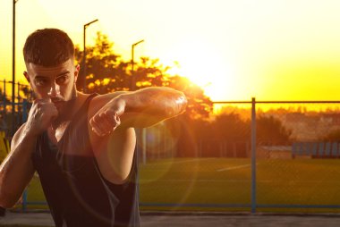 Sporcu gün batımında antrenman yapar. Boksör stadyumun yakınında ısınıyor. Yüzündeki dramatik gölgeleri sanatsal bir etki olarak görüyor. Çocuk parkındaki adam..
