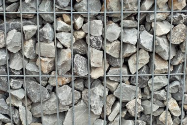 Çakıl taşı dokusu. Kaldırımlar eşit bir şekilde tel örgüye katlanmış. Mermer ve granit drenaj sistemi yakın plan..