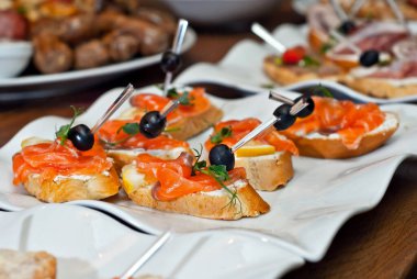 Havyarlı sandviç ve beyaz tabakta deniz ürünleri..