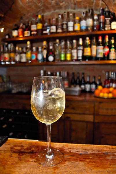 バーで黄色のカクテル 白ワインとホットワイン 背景にアルコールのボトルがぼやけて棚 — ストック写真