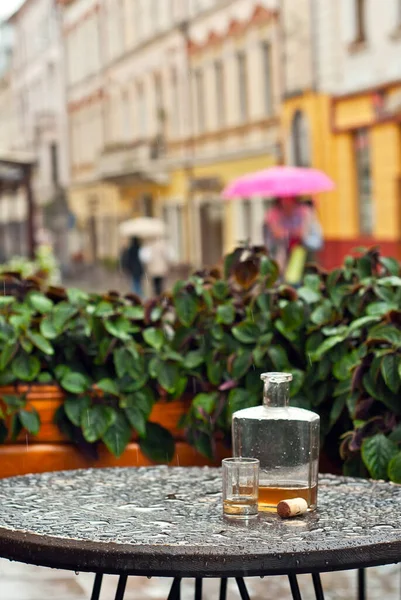 Eine Flasche Alkohol Neben Einem Glas Auf Einem Leeren Tisch — Stockfoto