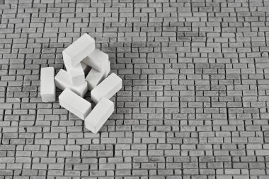 Yığının üzerinde gri beton tuğla. Tuğla dokusu yakın. Bloklar tuğla döşemeye yığılmış. Boşluğu ve boş alanı tuğlanın yanına kopyala.