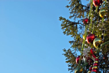 Geleneksel Noel süsleri Noel ağacında. Çok renkli çelenkler ve oyuncaklar kapanıyor.