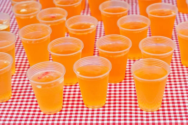 Masada Taze Meyve Kokteyli Var Plastik Bardaklarda Sarı Içecek Kareli — Stok fotoğraf