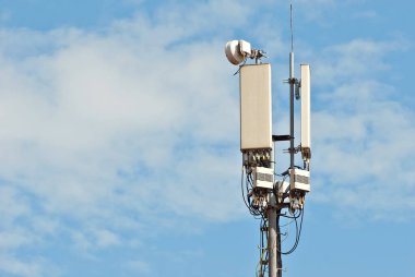 Mavi gökyüzünün arka planında antenleri olan kule. Demir kulede televizyon ve radyo antenleri.