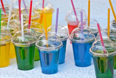 Çok renkli meyveli içecekler. Festivalde plastik bardaklarda alkolsüz içkiler. Meyve suyu ve sebzeli kokteyller..