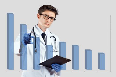 Doktor alçalan çizelgeye bakıyor. Hastalığı, aşıyı ve ölümlülüğü azaltma kavramı. Beyaz arka planda, doktor kıyafeti giymiş bir adam..