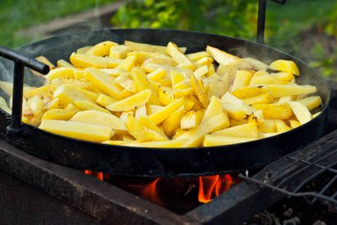 Büyük bir tavada patates kızartması. Festivalde nefis yemekler. Mutfak ocakta..