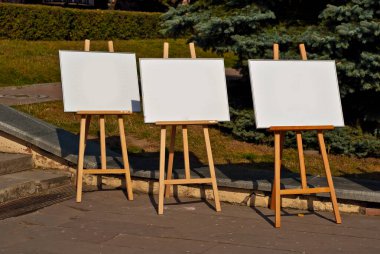 Sokakta bir sürü şövale var. Boş tuvalli yılanbalıkları yaklaş. Tasarım için tasarım. Resim üzerindeki metin için boşluk ve boşluk kopyala.