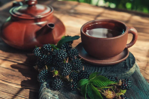 Fruit tea in a Cup with blackberries. Tea is made from berries and leaves of black raspberries.