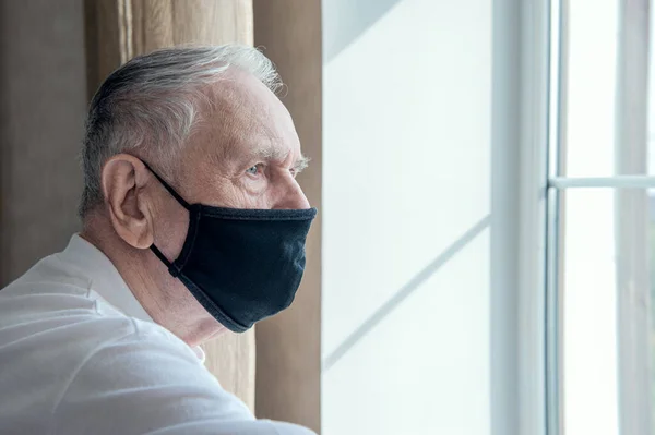 elderly man in a medical mask. He has the flu. Protecting people around you from the virus. concept of a pandemic. Close up. Copy space.