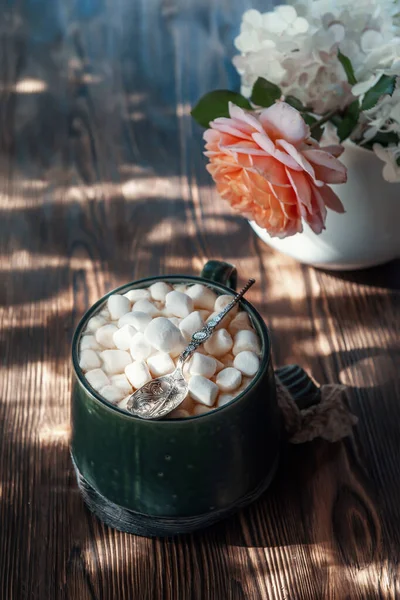 coffee with marshmallows. a delicious drink made of cocoa or hot chocolate with marshmallows in a cup on a wooden table. Still life in a rustic style with a beautiful openwork light