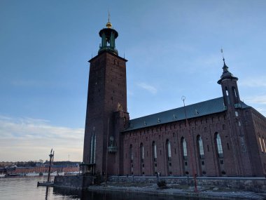 Stockholm, İsveç - 19 Nisan 2019: Stockholm Belediyesi veya Stadshuset manzarası 19 Nisan 2019 'da İsveç' te gün batımında.