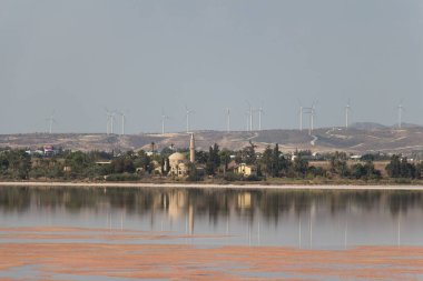 Larnaca, Kıbrıs - 16 Ekim 2019: Tuz gölü manzarası, Hala Sultan Tekke ve arka plandaki yel değirmeni 16 Ekim 2019 'da Kıbrıs Rum Kesimi' nin Larnaca kentinde.
