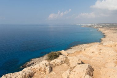 Kıbrıs Rum Kesimi 'nin güneşli bir günde Cape Greco etrafındaki kıyı şeridi manzarası.