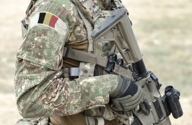 Askeri üniformalı, saldırı tüfeği ve Belçika bayrağı taşıyan asker. Kolaj. 