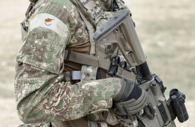 Silahlı asker ve askeri üniformalı Kıbrıs bayrağı. Kolaj. 