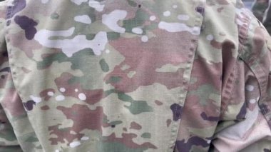 Amerikan askerleri. Amerikan ordusu. Amerikan askeri üniformasında ABD bayrağı var. Askerler tören alanının arkasında. Gaziler Günü. Anma Günü.