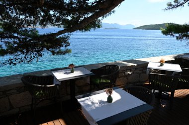 Adriyatik Denizi kıyısındaki bir kafede masalar. Akdeniz adası tatil beldesi. 
