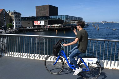 Kopenhag, Danimarka - 1 Ağustos 2024: Danimarka Kraliyet Tiyatrosu 'nun (Dedektif Kongelige Tiyatrosu) önünden bisikletçi geçişi).