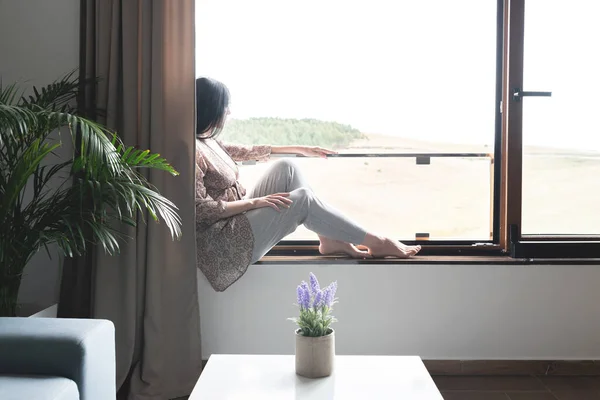 Schöne Frau Sitzt Auf Fensterbank Und Bewundert Die Aussicht Von — Stockfoto