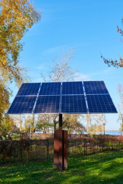 Güneşli bir günde parktaki güneş panelleri. Güzel bir sonbahar günü. Çevre koruma konsepti fotoğrafı. Yatay görüntü. Dikey fotoğraf. Kopyalama alanı ile yakın plan.
